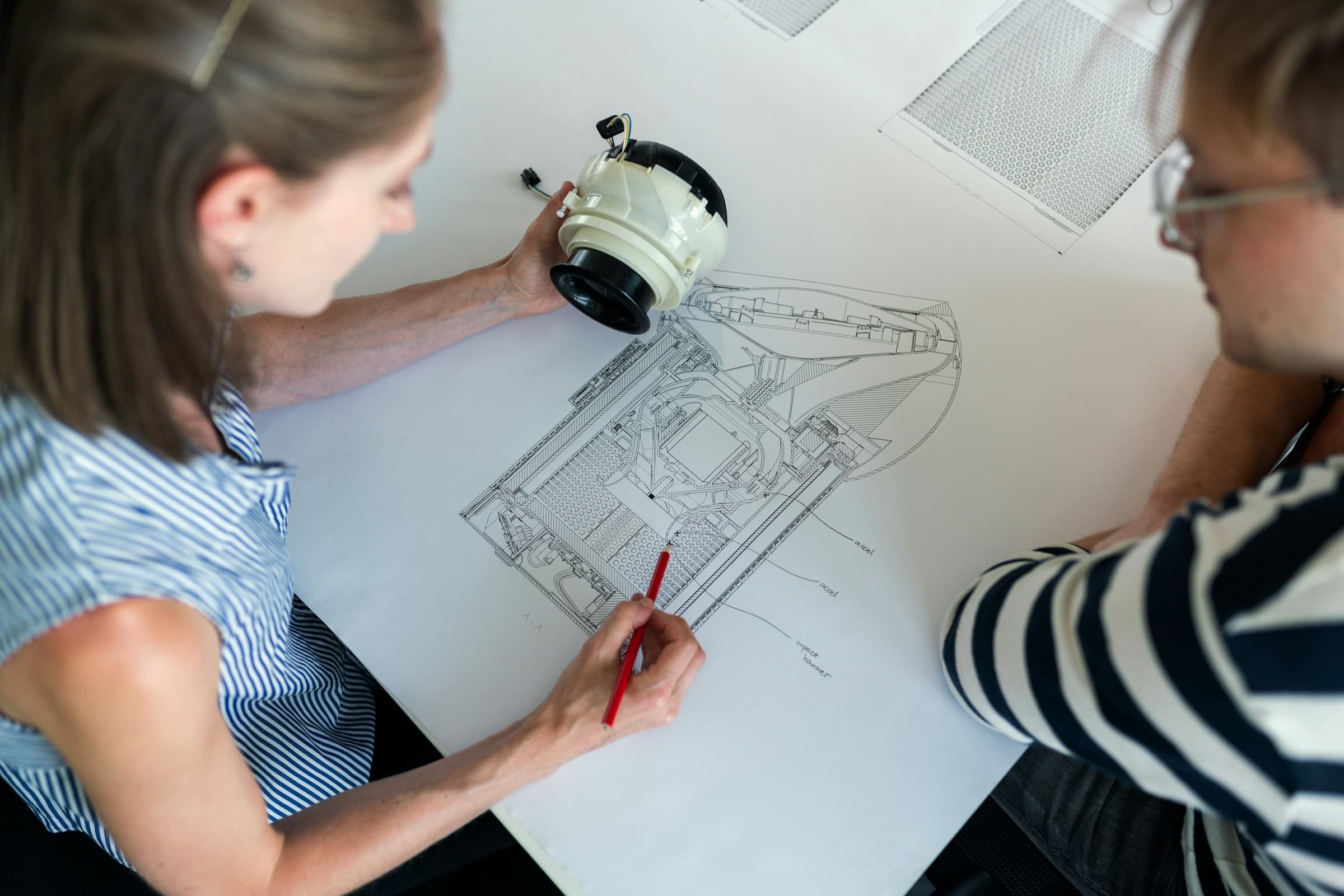 To personer tegner på et arbeidsbord